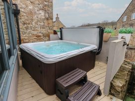 An outdoor area with a hot tub on a wooden deck at Mill Race House Alston