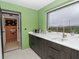 A kitchen with a sink and cabinetry at Twyn Isaf in Borth