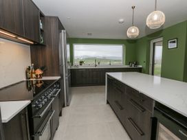 A kitchen with a large countertop and appliances at Twyn Isaf in Borth