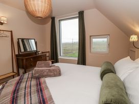 A bedroom with a bed and a dressing table at Twyn Isaf in Borth