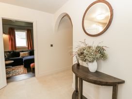 A hallway with a console table and flowers at Twyn Isaf in Borth
