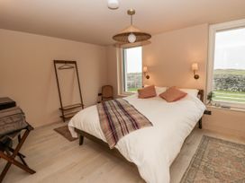 A bedroom with a bed and lamp at Twyn Isaf Borth