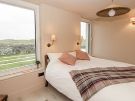 A bedroom with a bed and windows at Twyn Isaf in Borth