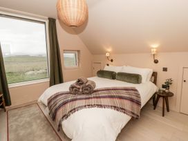 A bedroom with a bed and large window at Twyn Isaf in Borth