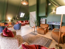 A living room with furniture and a foosball table at Twyn Isaf in Borth
