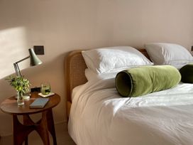 A bedroom with a bed, nightstand, flowers, and a lamp at Twyn Isaf in Borth