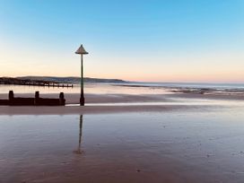 A beach with a fishing pier and lamp post at Twyn Isaf Borth