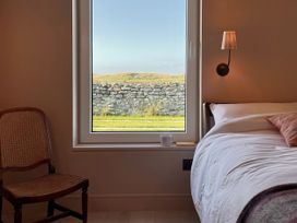 A bedroom with a window and a chair at Twyn Isaf in Borth
