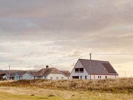 A row of houses with a cloudy sky at Twyn Isaf in Borth