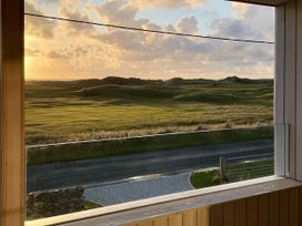 A view from a window featuring grass and sand dunes at Twyn Isaf in Borth
