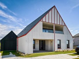 A house with distinctive architecture and landscaping at Twyn Isaf in Borth