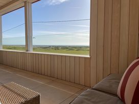 An indoor space with a view of the ocean and landscape at Twyn Isaf in Borth