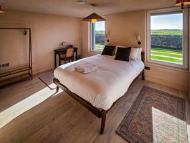 A bedroom with a bed and desk at Twyn Isaf in Borth