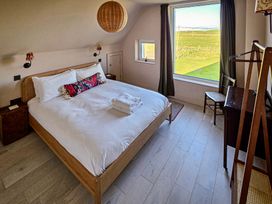 A bedroom with a bed and window view at Twyn Isaf Borth