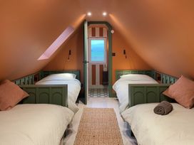 A bedroom with two beds and a window at Twyn Isaf in Borth