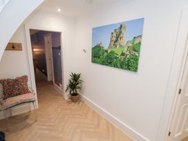 A hallway featuring a chair with a cushion and wall art at 32 Quay Street Scarborough