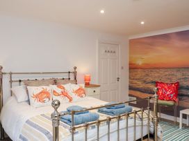 A bedroom with a metal bed and wall art at 32 Quay Street in Scarborough