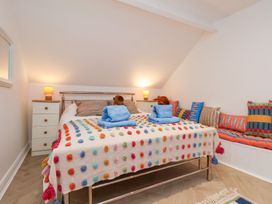A bedroom with a bed, side table, lamp, and cushions at 32 Quay Street Scarborough