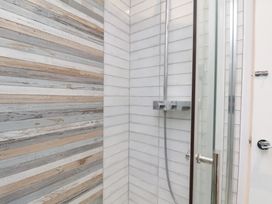 A bathroom with a shower and tiled walls at 32 Quay Street in Scarborough
