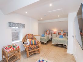 A bedroom with two beds and a rattan chair at 32 Quay Street Scarborough