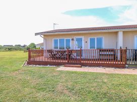 An outdoor space with a wooden deck and windows at Boa Vista in Bacton
