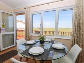 A dining room with a round table set for dinner at Boa Vista in Bacton