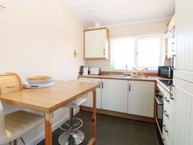 A kitchen with a table and stools at Boa Vista in Bacton
