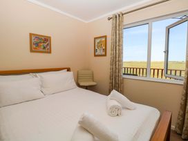 A bedroom with a bed and chair at Boa Vista in Bacton