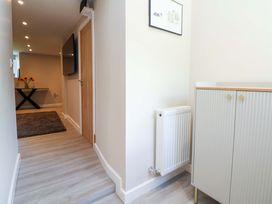 A hallway with a table and television at Cartref in Pen Y Ball near Holywell