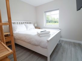 A bedroom with a bed and lamp at Cartref in Pen Y Ball near Holywell