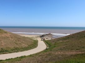 A beach view with a pathway leading to the sea at The Old Vicarage Annex Hornsea