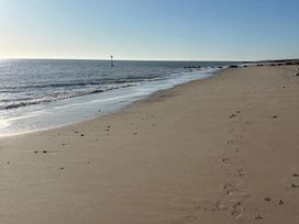 A beach with footprints in the sand at The Old Coach House at The Vicarage Mappleton near Hornsea