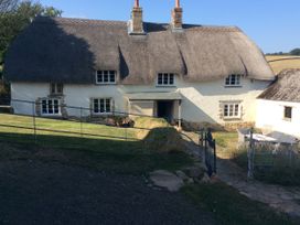 A thatched house with a garden and a gate at Westacombe Farm in Dunsford near Tedburn St Mary