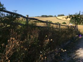 A fence along a field with grass and trees at Westacombe Farm Dunsford near Tedburn St Mary