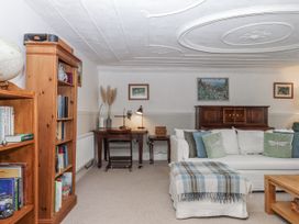 A living room with a sofa and bookshelf at Westacombe Farm in Dunsford