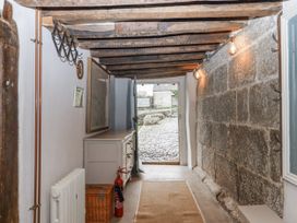 A hallway with stone walls and a door leading outside at Westacombe Farm in Dunsford