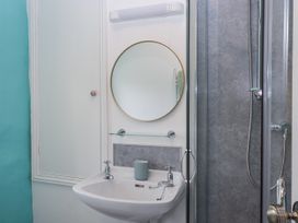 A bathroom with a sink, mirror, and shower at Westacombe Farm in Dunsford