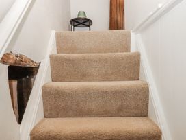 A staircase with carpet and a lamp at Westacombe Farm in Dunsford