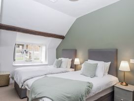 A bedroom with two beds and a window at Westacombe Farm in Dunsford