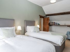 A bedroom with two beds and a shelf at Westacombe Farm in Dunsford