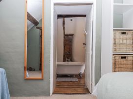 A bathroom with a bathtub and mirror at Westacombe Farm in Dunsford