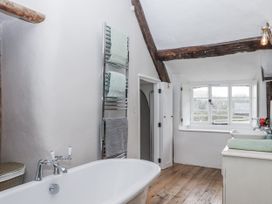 A bathroom with a bathtub, towel rack, and sink at Westacombe Farm in Dunsford