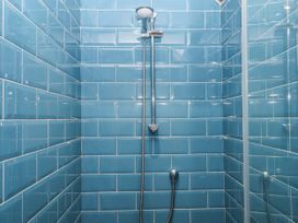 A shower with blue tiles and chrome fixtures at Westacombe Farm in Dunsford