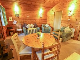 A wooden dining table with chairs and a living room area with armchairs and a two-seater sofa at Pheasant in Withern near Alford