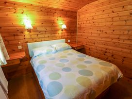 A bedroom with a double bed and wooden walls at Kestrel in Withern near Alford