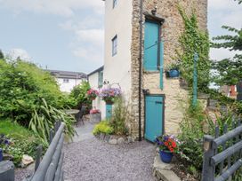 A garden with flowers, a table, and chairs at Tadworthy Tower in Northam