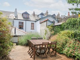 A garden with a wooden dining table and chairs at 12 Alpha Place Appledore