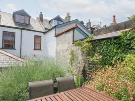 A garden with a table and flower beds at 12 Alpha Place Appledore