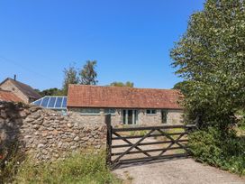 A property with stone wall and gate at Dragon Cottage in Musbury