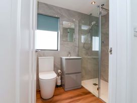 A bathroom with a toilet, sink, and shower at Kernyk in Camelford